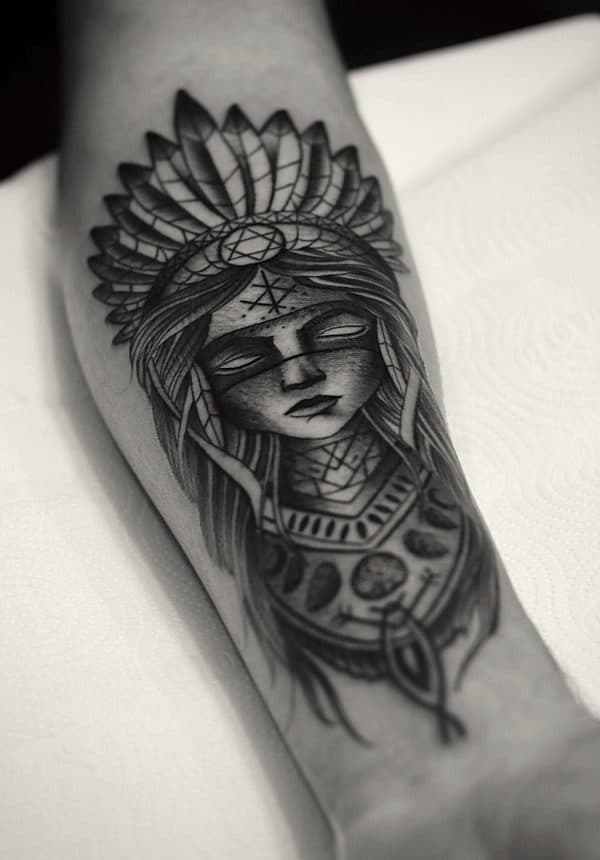 a black and grey portrait piece on a forearm